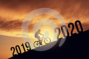 2020 new year concept with the silhoutte of a bicycle rider, metmorphing the changes of years