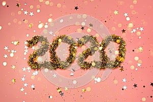 2020 new year gold numbers on a coral color background with scattered stars