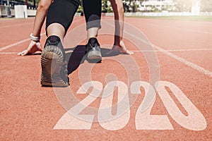 2020 Newyear , Athlete Woman starting on line for start running with number 2020 Start to new year