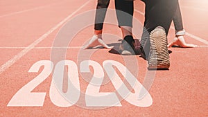 2020 Newyear , Athlete Woman starting on line for start running with number 2020 Start to new year