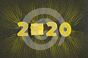 2020 numbers decorated with gold sequins,  ribbon, ball on shiny black background.