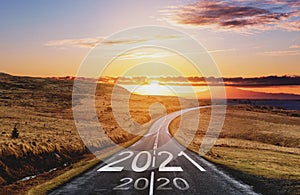 2021 and 2020 on the empty road at sunset. New Year concept