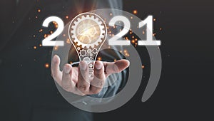 2021 goal, target business concept, hand of businessman with a light bulb The idea of â€‹â€‹inspiration fro