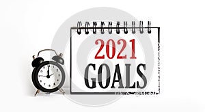 2021 GOALS notepad writing on the white background with alarm clock