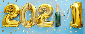 2021 golden balloon text on blue background bottle of champagne and glasses with confetti. Happy New year eve invitation with