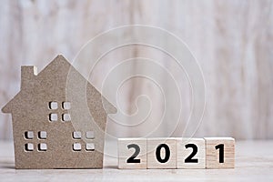 2021 Happy New Year with house model on table wooden background. Banking, real estate, investment, financial, savings and New Year