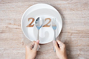 2021 Happy New Year and New You with white plate on wood background. Goals, Healthy, Healthcare, Resolution, Time to New Start,