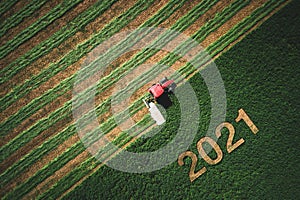 2021 Happy Ney Wear concept and red tractor mowing green field