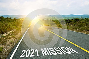 2021 mission inscription on straight road. Sunny morning landscape. Motivational inscription on the road going forward. The