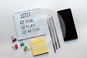 2021 new year goal,plan,action text on notepad with office accessories