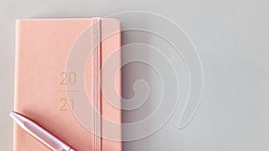 2021 New year pink slim diary and pen with gray background. details.