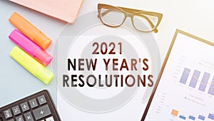 2021 New Year`s resolution text on office paper, on desktop