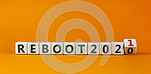 2021 reboot new year symbol. Fliped wooden cube and changed words `Reboot 2020` to `Reboot 2021`. Beautiful orange background,