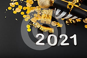 2021 white text lettering on black background with golden confetti, Christmas gift boxes gold balls festive decor. Happy New year