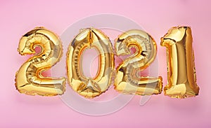 2021 year air balloon numbers on pink background. Happy New year eve invitation with Christmas gold foil balloons 2021. Flat lay