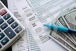 2022 blank tax form with money cash pen and calculator