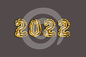 2022 golden foil balloons decor and Christmas snow with copy space on a brown background. New Year concept