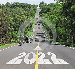 2022 Happy New Year concept with motorcyclists traveler driving across the slope country asphalt road uphill