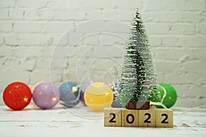2022 Happy New Year festive background with christmas tree on white brick wall background