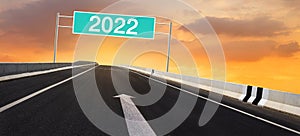 2022 on Highway road sign and golden sky.