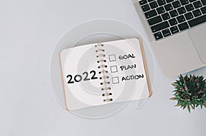 2022 new year goal,plan,action concepts with text on notepad and computer laptop on background