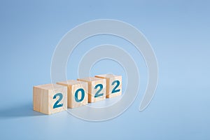 2022 number on wooden block on blue background