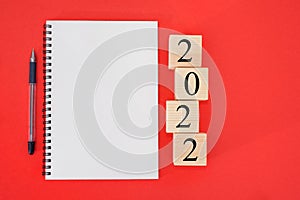 2022 is the time for a fresh start. Word plan and 2022 cubes on a red background. New Year. plans for 2022, place for text in