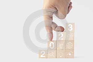 2023 business growing growth concept to success. fingers are walking down woods block step with icon concept about business