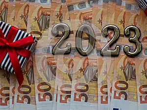 2023 and gift box on the background of fifty euros banknotes