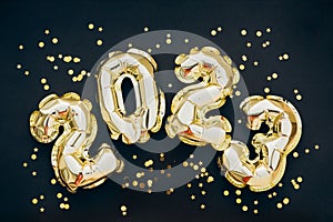 2023 golden decoration holiday on trendy background. Shiny party background. Gold foil balloons numeral 2023 with glitter gold