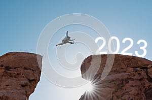 2023 new year concept, silhouette a man jumping to 2023