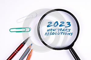 2023 New Year's Resolutions. Magnifying glass on a white background