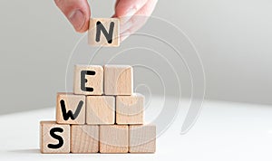 2023 News new year symbol. Businessman turns a wooden cube and changes words News 2022 to News 2023. Beautiful grey