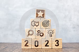 2023 wood block with business success, goal, strategy, target, mission, action, objective, teamwork, plan, idea and New Year start