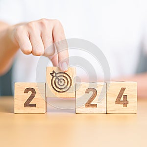 2023 year change to 2024 year block with dartboard icon. Goal, Target, Resolution, strategy, plan, Action, mission, motivation,