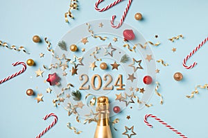 2024 christmas and New Year composition with champagne bottle, fir tree, party streamers, confetti stars and decorations. Flat lay