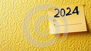 2024 date handwritten in a text script with a black marker pen on paper note pad memo placed on a yellow background