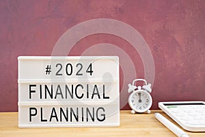 2024 financial planning written white lightbox sitting and calculatoron worktable