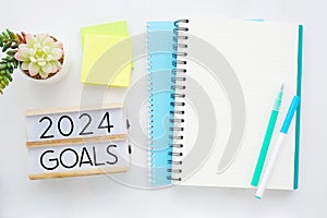 2024 goals on wood box and blank notebook paper background, 2024 business new year template