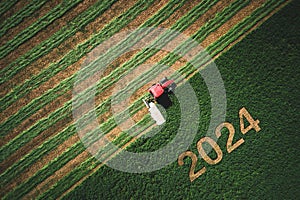 2024 Happy Ney Wear concept and red tractor mowing green field