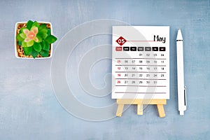 2024 May calendar page and pen with plant pot on wooden background