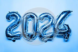 2024 New Year Concept - blue foil balloon and confetti