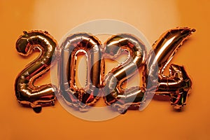 2024 New Year Concept - Orange foil balloon and confetti
