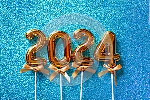 2024 New Year numbers Concept - Orange old gold numbers on light blue glitter background