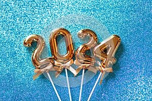 2024 New Year numbers Concept - Orange old gold numbers on light blue glitter background