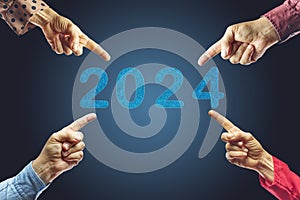 2024, People pointing to the number 2024 on blue background. Happy New Year