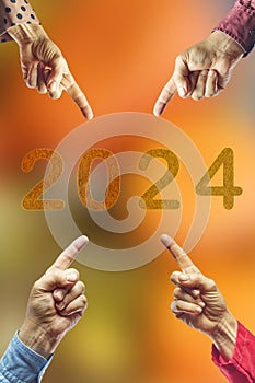 2024, People pointing to the number 2024 on orange background. Happy New Year