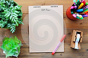 2024 plans on blank notebook paper on wood background, 2024 new year mock up, template, flat lay