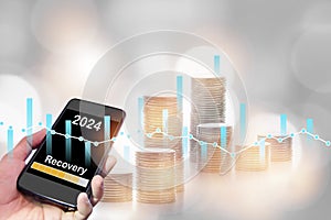 2024 recovery on smartphone with stack of coin and growth graph on bokeh background