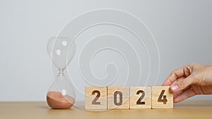 2024 text with hourglass on table. Resolution, time, plan, goal, motivation, reboot, countdown and New Year holiday concepts